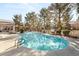 A sparkling community pool surrounded by mature trees and comfortable lounge seating at 555 E Silverado Ranch Blvd # 2114, Las Vegas, NV 89183