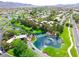 Aerial shot of neighborhood featuring homes with landscaping, ponds, and streets, nestled against a mountain backdrop at 71 Fountainhead Cir, Henderson, NV 89052