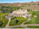 Aerial view of a large property with a sprawling building, golf course, and landscaped grounds in a mountain setting at 71 Fountainhead Cir, Henderson, NV 89052