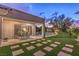 Lush backyard featuring an inviting patio, manicured lawn, and a beautiful view of the sunset sky at 71 Fountainhead Cir, Henderson, NV 89052