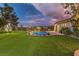 Expansive backyard featuring a pristine pool, lush lawn, and charming play structure at 71 Fountainhead Cir, Henderson, NV 89052