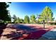 Outdoor basketball court on a sunny day, surrounded by trees and landscaping, providing an recreational space at 71 Fountainhead Cir, Henderson, NV 89052