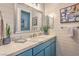 Modern bathroom with blue vanity, marble countertop, and horizontally paneled walls at 71 Fountainhead Cir, Henderson, NV 89052