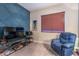 Cozy bedroom featuring blue accent wall, comfortable seating, and ample natural light at 71 Fountainhead Cir, Henderson, NV 89052