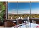 Refined dining area with a table set for a meal, framed by large windows offering scenic views of mountains and landscaping at 71 Fountainhead Cir, Henderson, NV 89052