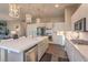 Bright, modern kitchen with white cabinets, stainless steel appliances, and beautiful pendant lighting at 71 Fountainhead Cir, Henderson, NV 89052