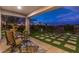 Cozy outdoor patio area with comfortable seating and scenic views of the yard and sunset sky at 71 Fountainhead Cir, Henderson, NV 89052