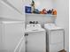 Laundry room with white appliances, storage shelf and a white door at 7348 N Decatur Blvd # 5, Las Vegas, NV 89131