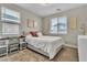 Cozy bedroom with natural light, a desk, and a comfortable bed adorned with decorative pillows at 741 Monroe Hill Pl, Henderson, NV 89011