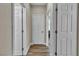Hallway with multiple white doors, wood-look flooring, and neutral wall paint at 741 Monroe Hill Pl, Henderson, NV 89011