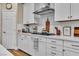 Close-up of the white kitchen featuring sleek countertops and subway tile backsplash at 741 Monroe Hill Pl, Henderson, NV 89011