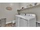 Functional laundry room with modern appliances, shelving for storage, and tiled floors at 741 Monroe Hill Pl, Henderson, NV 89011