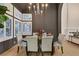 Bright dining room with a dark table, elegant chairs, and abundant natural light from surrounding windows at 9 Cozy Glen Cir, Henderson, NV 89074