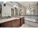 Luxurious bathroom with dual sinks, soaking tub, and tile surround, offering a spa-like experience at 9425 San Laguna Ct # 102, Las Vegas, NV 89134