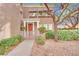 Charming home entrance with a decorative wood door and mature landscaping at 9425 San Laguna Ct # 102, Las Vegas, NV 89134