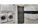 Practical laundry area with white washer and dryer, storage cabinets and black refrigerator at 9425 San Laguna Ct # 102, Las Vegas, NV 89134