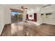 Bright living room featuring hardwood floors, a balcony with wrought iron railing, and custom built-in shelving at 9425 San Laguna Ct # 102, Las Vegas, NV 89134