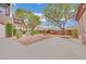 A paved parking area with desert landscaping and mature trees at 9425 San Laguna Ct # 102, Las Vegas, NV 89134