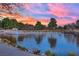 Scenic pond reflects a colorful sunset sky, framed by lush trees and a manicured landscape at 9425 San Laguna Ct # 102, Las Vegas, NV 89134