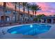 Community pool and spa surrounded by tropical palm trees and comfortable lounge area at 9425 San Laguna Ct # 102, Las Vegas, NV 89134