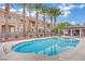 Community pool and lounge area surrounded by well-maintained landscaping and palm trees at 9425 San Laguna Ct # 102, Las Vegas, NV 89134