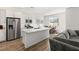 Modern kitchen with stainless steel appliances, an eat-in island with marble countertops and dining area at 9666 S Conquistador St, Las Vegas, NV 89178