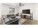 Bright living room with a ceiling fan, large television, and a comfortable gray sectional sofa at 9666 S Conquistador St, Las Vegas, NV 89178