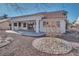 Covered patio overlooking a beautifully landscaped backyard with decorative rock and mature trees at 9704 Brawley Dr, Las Vegas, NV 89134