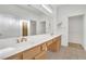 Bright bathroom featuring double sinks, vanity with wood cabinets and a large mirror at 9704 Brawley Dr, Las Vegas, NV 89134