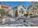 Beautiful house with a front yard landscaped with manicured bushes, stone, and mature trees at 9704 Brawley Dr, Las Vegas, NV 89134