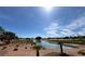 Scenic view of a well-maintained golf course with a beautiful pond and palm trees under a blue sky at 9704 Brawley Dr, Las Vegas, NV 89134