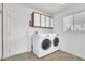Well-lit laundry room featuring a washer, dryer, storage cabinets, and a neutral color scheme at 9704 Brawley Dr, Las Vegas, NV 89134