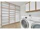 Functional laundry area with washer, dryer, storage cabinets, and open shelving for organized convenience at 9704 Brawley Dr, Las Vegas, NV 89134