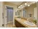 Well-lit bathroom featuring double sinks with sleek dark wood cabinets and a framed mirror at 9950 Waxberry Ct, Las Vegas, NV 89178
