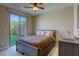 Cozy bedroom with a sliding glass door to the backyard, a bed, and a dresser at 9950 Waxberry Ct, Las Vegas, NV 89178