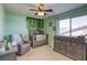 Bright Bedroom with modern décor, featuring a crib, changing table, and a comfortable armchair at 9950 Waxberry Ct, Las Vegas, NV 89178