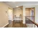Bright hallway featuring hardwood floors, table with decor, and a view of the second story at 9950 Waxberry Ct, Las Vegas, NV 89178