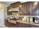 Detailed view of a kitchen with granite counters, stainless steel appliances, and dark wood cabinets at 9950 Waxberry Ct, Las Vegas, NV 89178