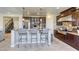 Kitchen with a large island, modern stainless steel appliances, dark wood cabinets, and stone tile flooring at 9950 Waxberry Ct, Las Vegas, NV 89178