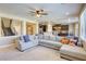 Open-concept living room with a plush sectional, flowing into the kitchen and featuring a staircase at 9950 Waxberry Ct, Las Vegas, NV 89178