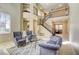 Open-concept living room with soaring ceilings, a grand staircase, and stylish furnishings for a luxurious appeal at 9950 Waxberry Ct, Las Vegas, NV 89178