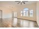 Bright living room with vaulted ceilings, wood floors, a ceiling fan, and large windows at 10147 Aspen Rose St # 101, Las Vegas, NV 89183