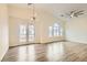 Bright living room with wood floors, vaulted ceilings, a ceiling fan, and access to a balcony at 10147 Aspen Rose St # 101, Las Vegas, NV 89183