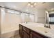 Bright bathroom featuring a double sink vanity, large mirror, and a shower-tub combination at 10808 Holmfield St, Henderson, NV 89052