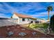 Spacious backyard with a covered patio, lush lawn, and rock features at 1107 Cloudy Day Dr, Henderson, NV 89074