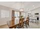 Well-lit dining area with a wood table and a view of the modern kitchen with white cabinets and stainless steel appliances at 1107 Cloudy Day Dr, Henderson, NV 89074