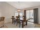 Charming dining area features a rustic wood table, modern light fixture, and sliding glass doors to the backyard at 1107 Cloudy Day Dr, Henderson, NV 89074