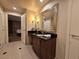 A vanity with rich wood cabinets and granite countertops sits adjacent to the bedroom entry at 135 E Harmon Ave # 2120, Las Vegas, NV 89109