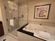 Bright bathroom featuring a glass shower and a luxurious jacuzzi tub with decorative wall art at 135 E Harmon Ave # 2120, Las Vegas, NV 89109
