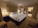 Well-appointed bedroom featuring a king bed with a padded headboard, nightstand, and doorway to bathroom at 135 E Harmon Ave # 2120, Las Vegas, NV 89109